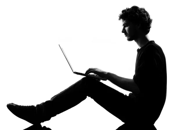 Σιλουέτα νεαρός άνδρας κάθεται υπολογιστών lap-top — Φωτογραφία Αρχείου