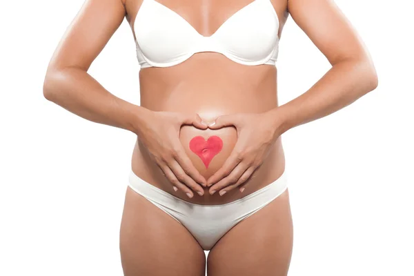 Kobieta w ciąży z sercem na brzuchu — Zdjęcie stockowe