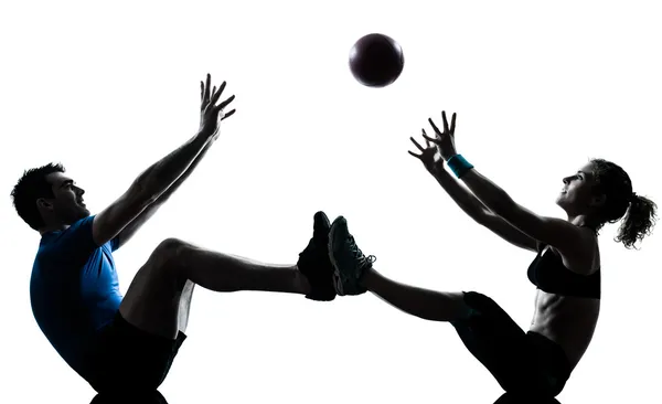 Man woman exercising workout tossing fitness ball Royalty Free Stock Images