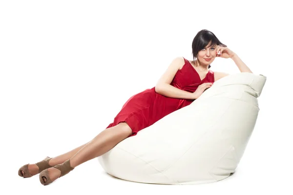Woman in red dress laying on armchair — Stock Photo, Image