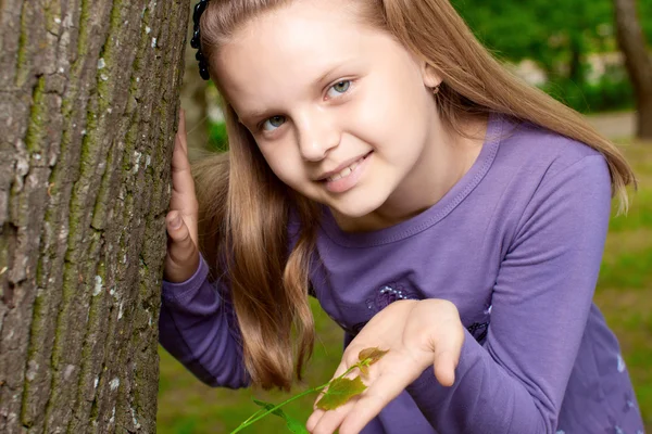 Girl shows green shoot of tree — Stock Photo, Image