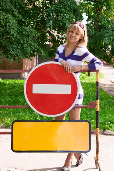 Young woman over the warning road signes — Stock Photo, Image