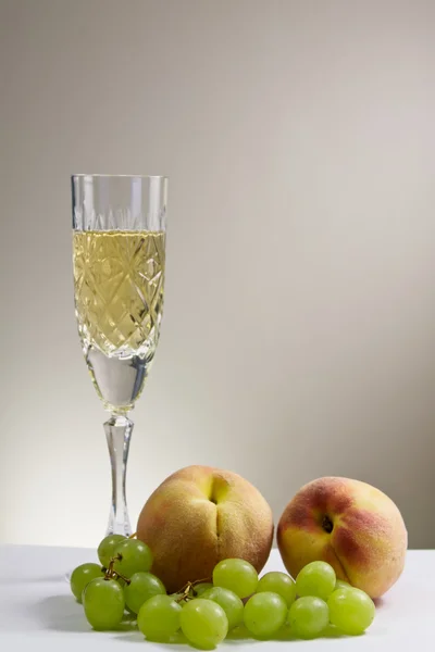 พีชและองุ่นกับแก้วไวน์ — ภาพถ่ายสต็อก