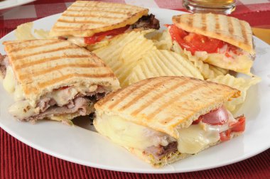 Grilled roast beef panini with potato chips clipart