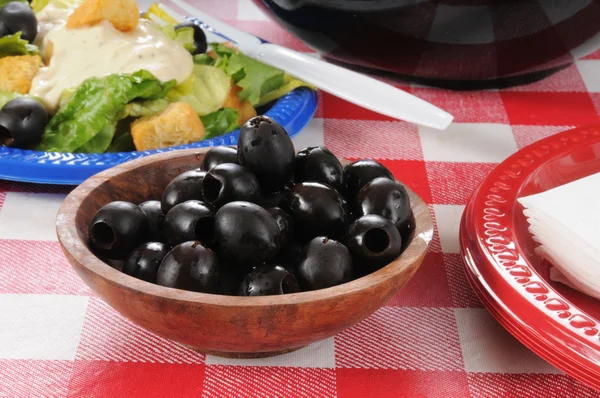 Zwarte olijven op een picknicktafel — Stockfoto
