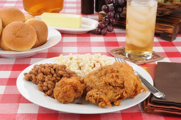 Fried chicken and baked beans on a picnic table — Stock Photo, Image
