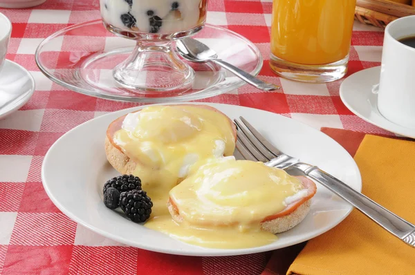 Eggs benedict with fruit cocktail — Stock Photo, Image