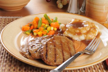 Salisbury steak dinner with mixed vegetables clipart