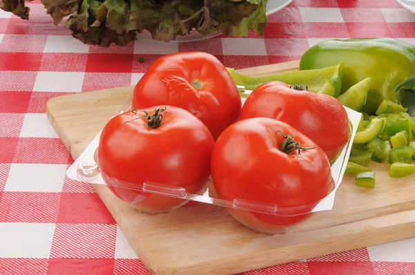 Kontejner čerstvých rajčat se zelenými paprikami — Stock fotografie