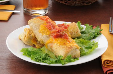 Plate of chimichangas with cheese clipart