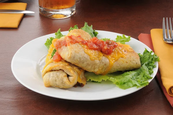 Chimichangas topped with cheddar cheese — Stock Photo, Image