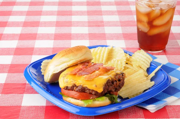 Bacon cheeseburger on a picnic table — Stock Photo, Image