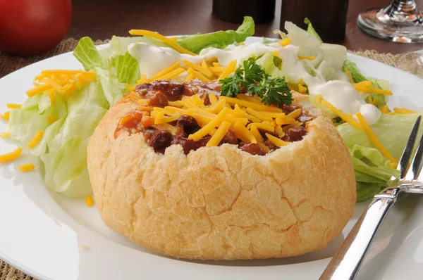 Chili in einer Brotschale mit Salat — Stockfoto