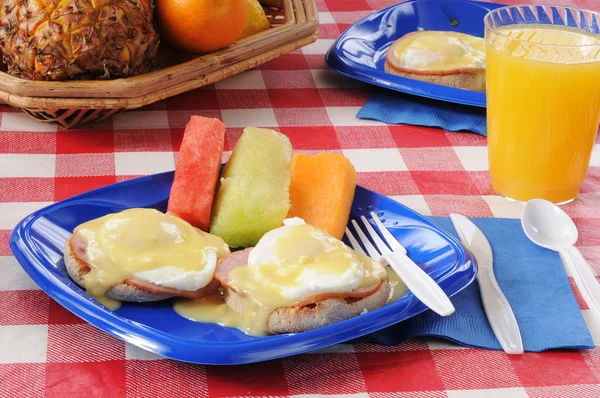 Eggs Benedict with fresh melon slices — Stock Photo, Image
