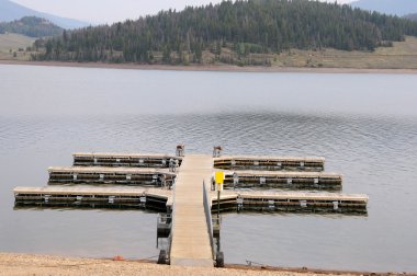 Boat dock at a mountain lake clipart