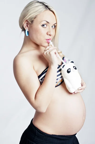 Beautiful pregnant woman drinking from funny cup — Stock Photo, Image