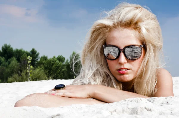 Hermosa mujer rubia en gafas de sol en la arena — Foto de Stock