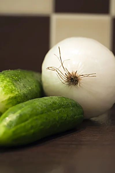 Fresh cucumbers and onion in the kitchen — Stock Photo, Image