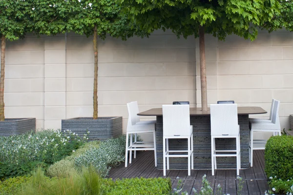 Спокойный сад со столом и стульями — стоковое фото