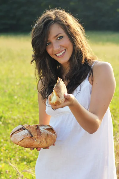 Красивая девушка предлагает кусок хлеба — стоковое фото