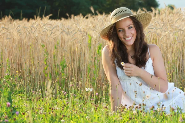 Молодая и счастливая девушка в сенной шляпе — стоковое фото
