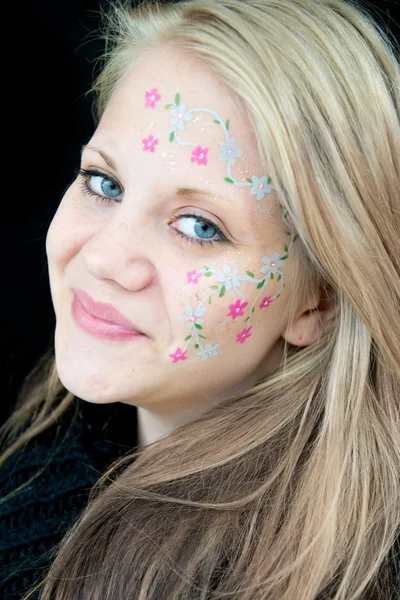 Cute girl with a flowery face painting — Stock Photo, Image