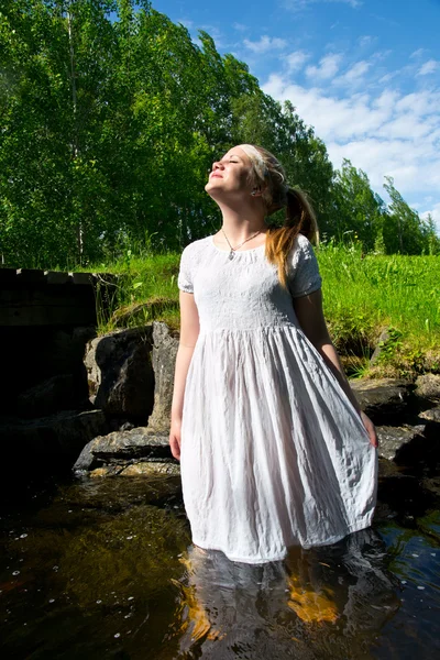 Женщина в белом платье наслаждается солнцем — стоковое фото