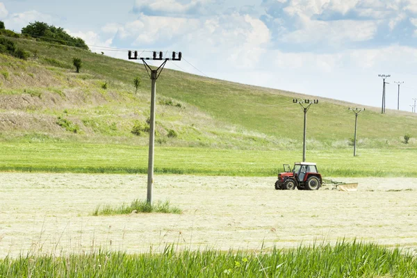 stock image Tractor in a field - agricultural scene in summer