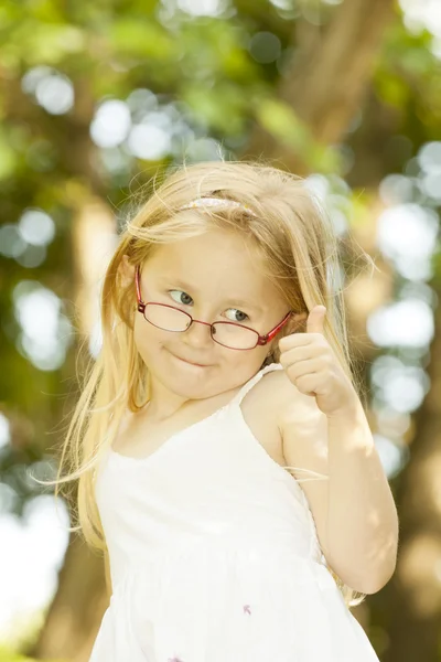 Happy little girl showing thumbs up. Outdoor — Stock Photo, Image