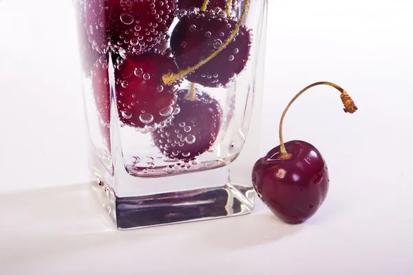 Cereja doce em vidro com água — Fotografia de Stock