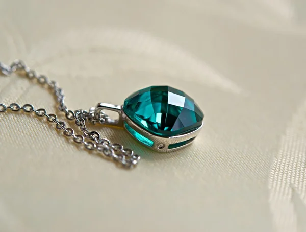 Pendant with green stone on a chain — Stock Photo, Image