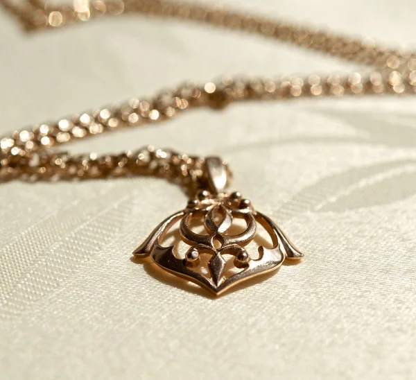 Gold pendant on a chain — Stock Photo, Image