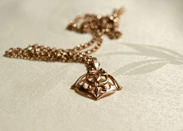 Gold pendant on a chain — Stock Photo, Image