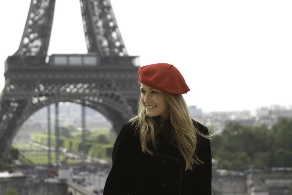 Женская модель на фоне Эйфелевой башни в красной шляпе — стоковое фото