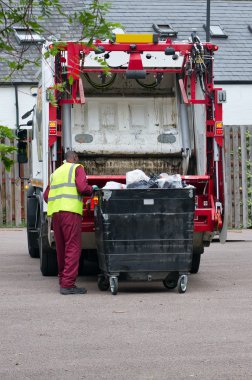 Bin man collecting the rubbish from a large bin clipart