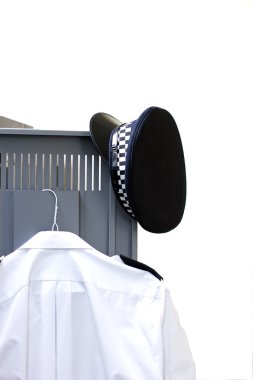 Policemans hat and shirt hanging on a locker door clipart