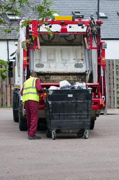 Homem de lata recolhendo o lixo de um grande caixote — Fotografia de Stock
