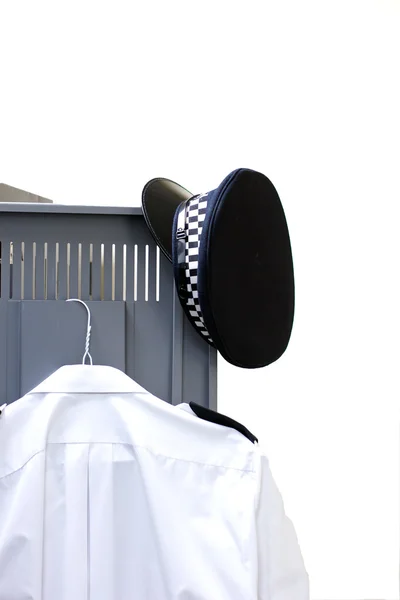 Policemans 的帽子和衣服挂在衣柜门上 — 图库照片