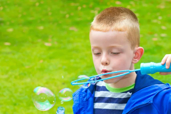 Boy blowing bubbles — Stock Photo, Image