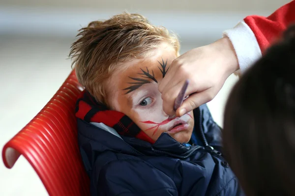 Little boy having his face painted like a tiger — Stock Photo, Image