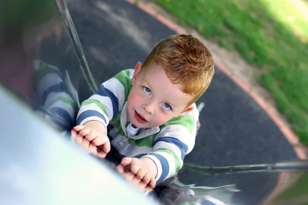 Mały chłopiec slding dół slajdu w parku — Zdjęcie stockowe