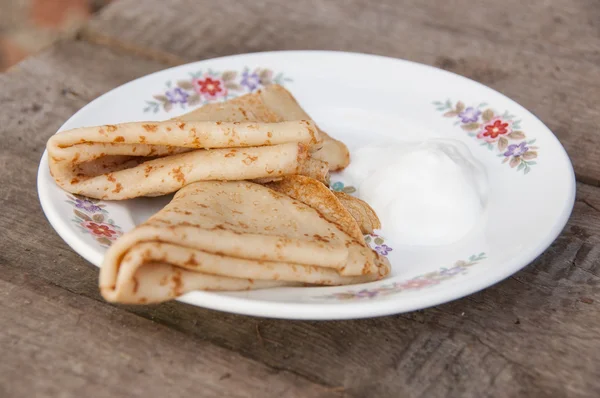 Two pancakes with sour cream on a plate — Stock Photo, Image