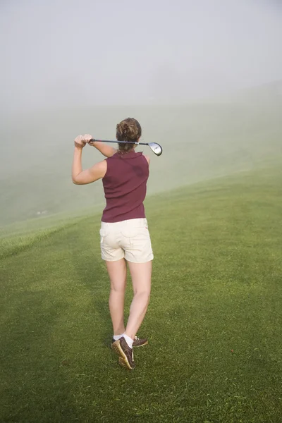 Žena v jejím chmelařské hrát golf — Stock fotografie