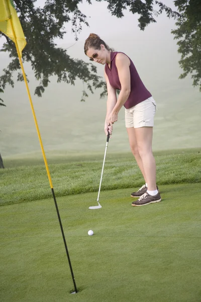 Mujer de unos 20 años jugando al golf —  Fotos de Stock