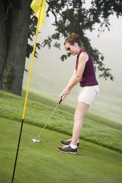 Donna sulla ventina che gioca a golf — Foto Stock