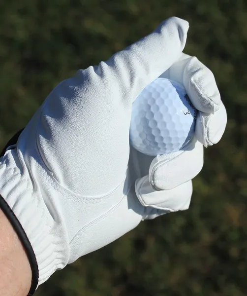 Pelota de golf en mano ganada — Foto de Stock