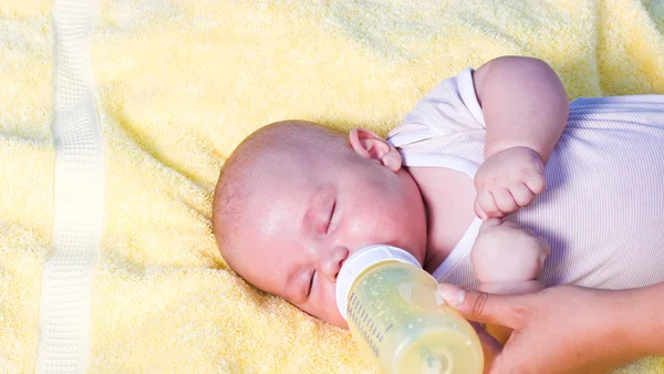 Baby boy drinking milk from bottle — Stock Photo, Image