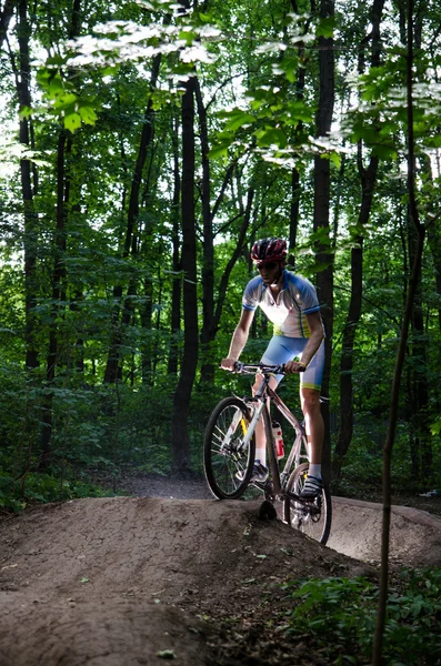 Byciclyst trains on the ramp in the forest — Stock Photo, Image