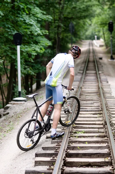 Byciclyst climbing on the railroad — Stock Photo, Image