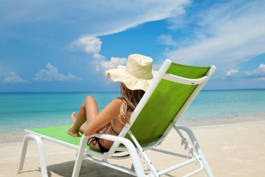 Woman relaxing on a beach clipart